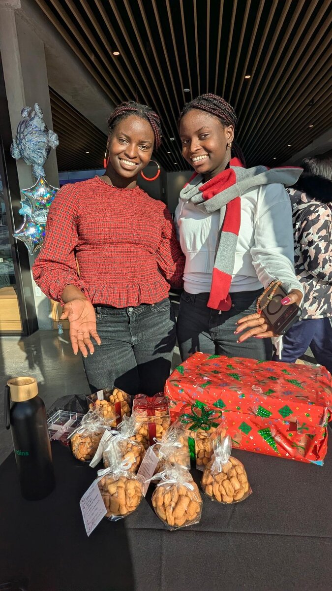 Twin sisters smiling together at their TwinChin market table